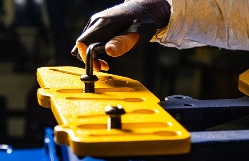 Mans hand turning a bolt, CNC lathes & mills fabricating