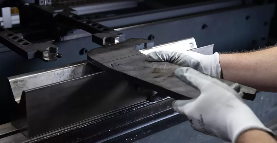 Man operating a brake press machine, metal fabrication.