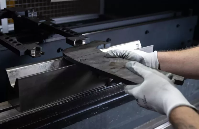 Man operating a brake press machine, metal fabrication.